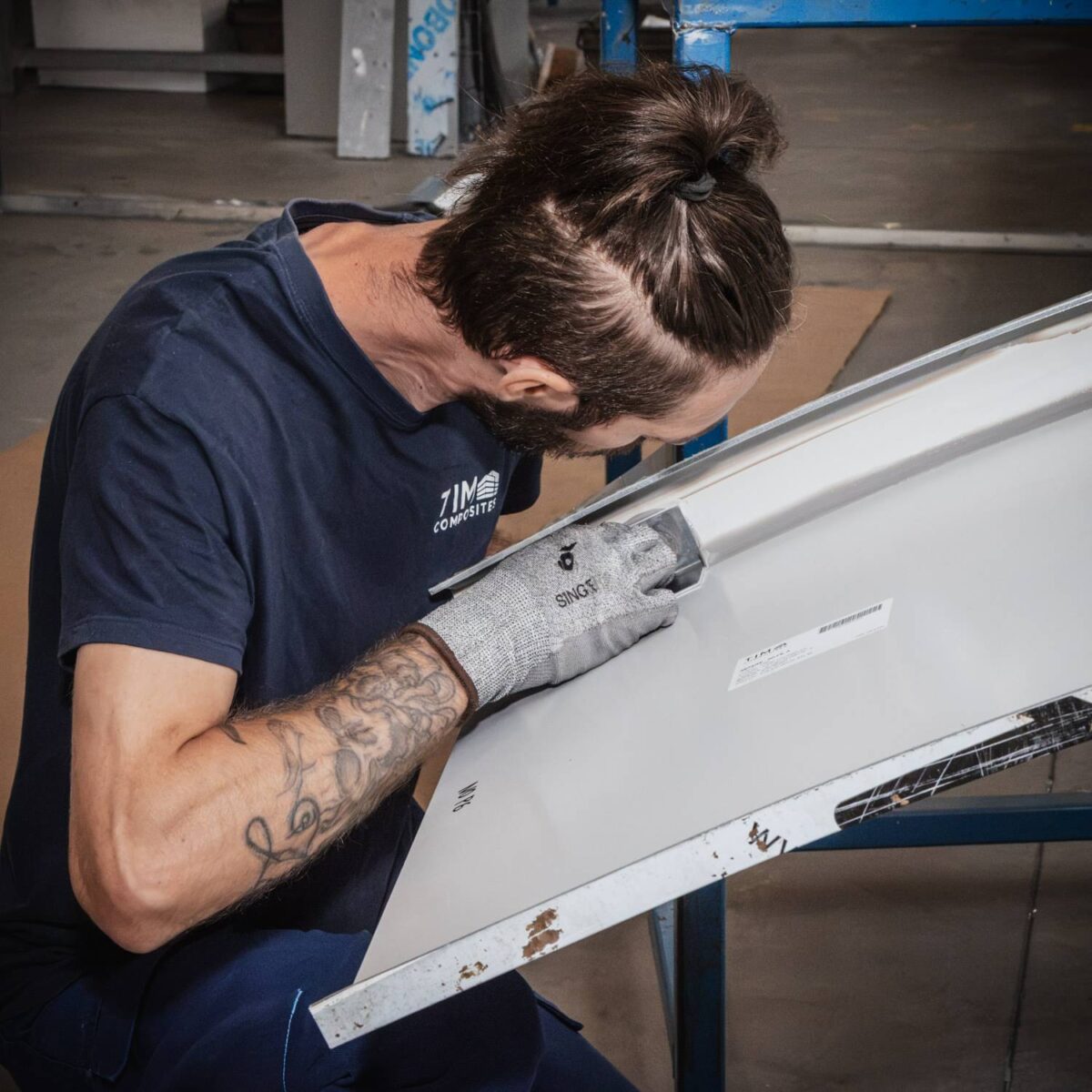 Collaborateur TIM Composites façonnant un panneau aluminium cintré